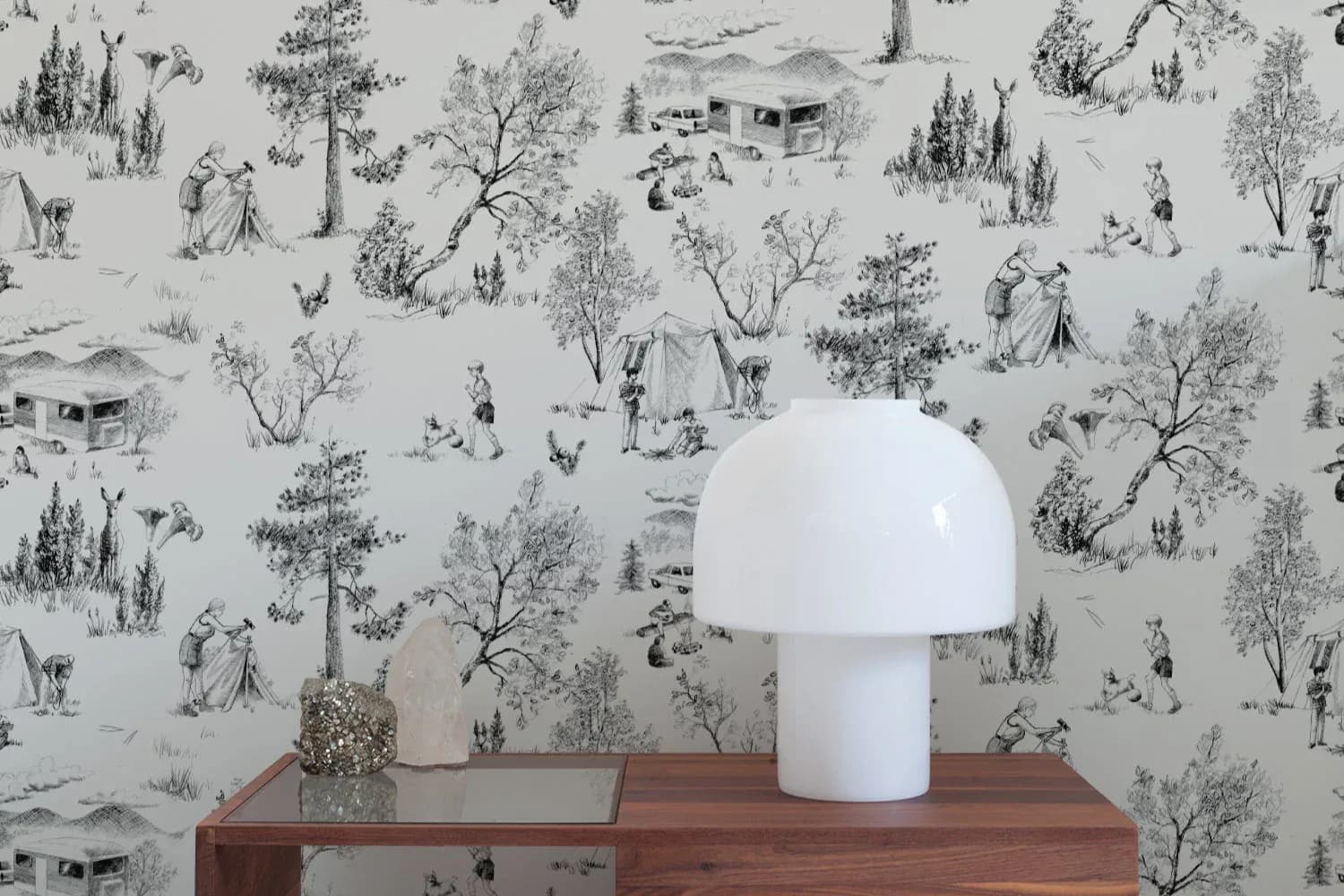 Modern minimalist interior with a white mushroom-shaped table lamp on a wooden desk, set against a gray wallpaper featuring delicate botanical and figure illustrations by Aimee Wilder.