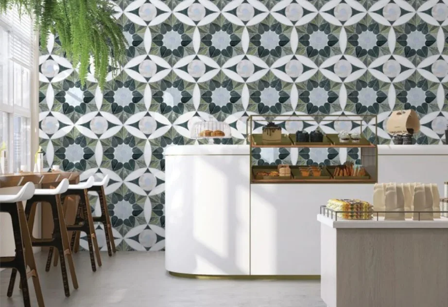 Modern retail interior with geometric patterned wallpaper, white curved counter, wooden shelving, and natural light by Allison Eden.
