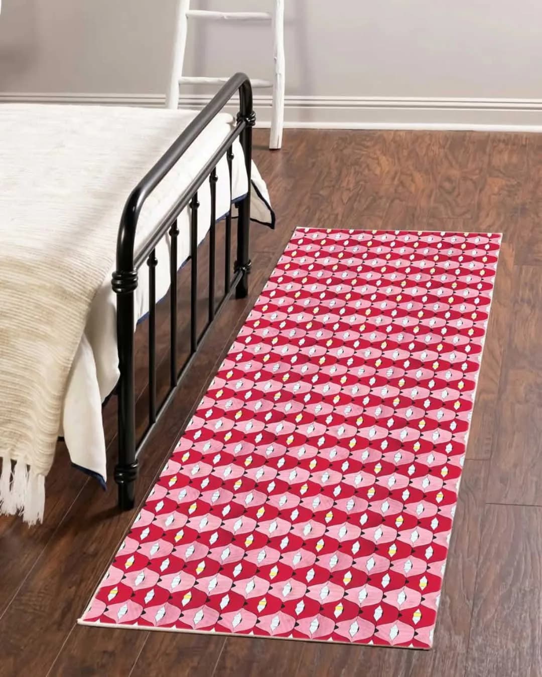 Bedroom with black metal bed frame and red patterned runner rug on wood flooring, designed by Allison Eden.