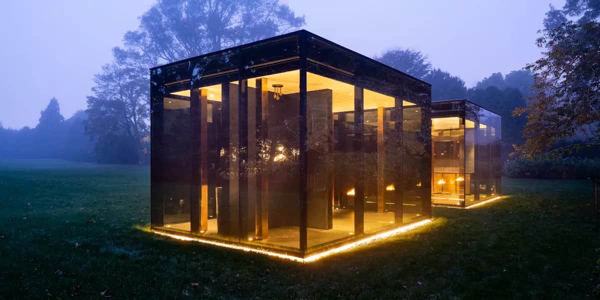 Modern glass pavilion with black steel frame illuminated by warm golden lighting at dusk, surrounded by misty trees and green field, by Ana Rojas.