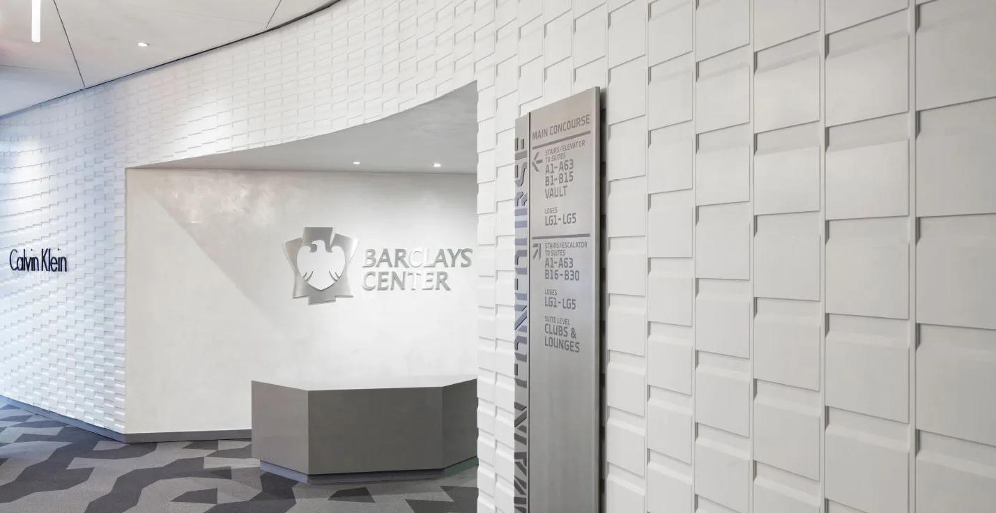 Modern office reception area with clean white brick walls, curved dark reception desk, and minimalist aesthetic by Andrew Baccon.