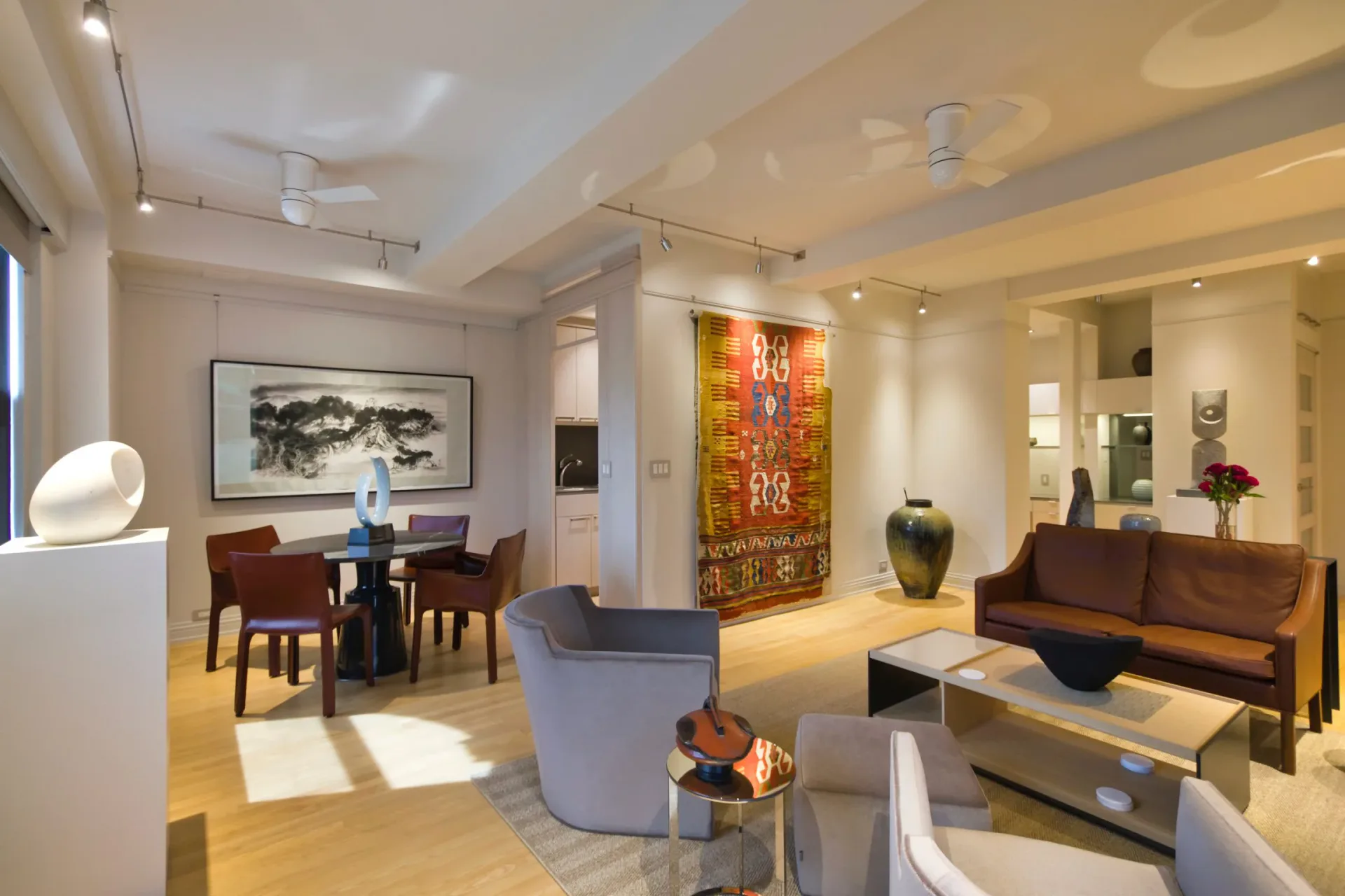 Modern residential living space featuring warm wood tones, neutral palette, decorative Asian artwork, sculptural lighting fixtures, and contemporary furniture by Andy Schwalen.