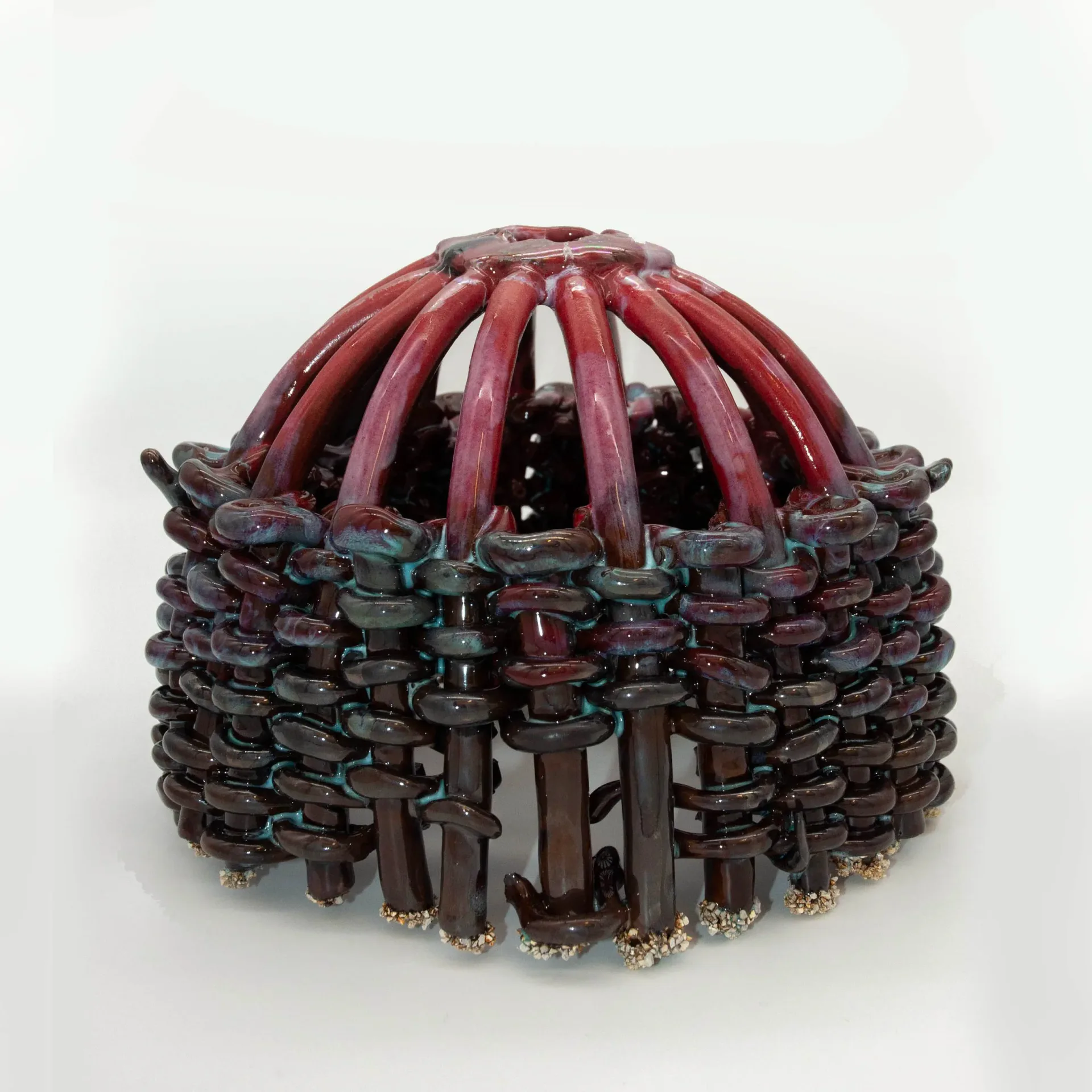 Sculptural object with crimson ribbed dome and layered dark teal and burgundy organic forms with metallic accents, designed by Anina Major.