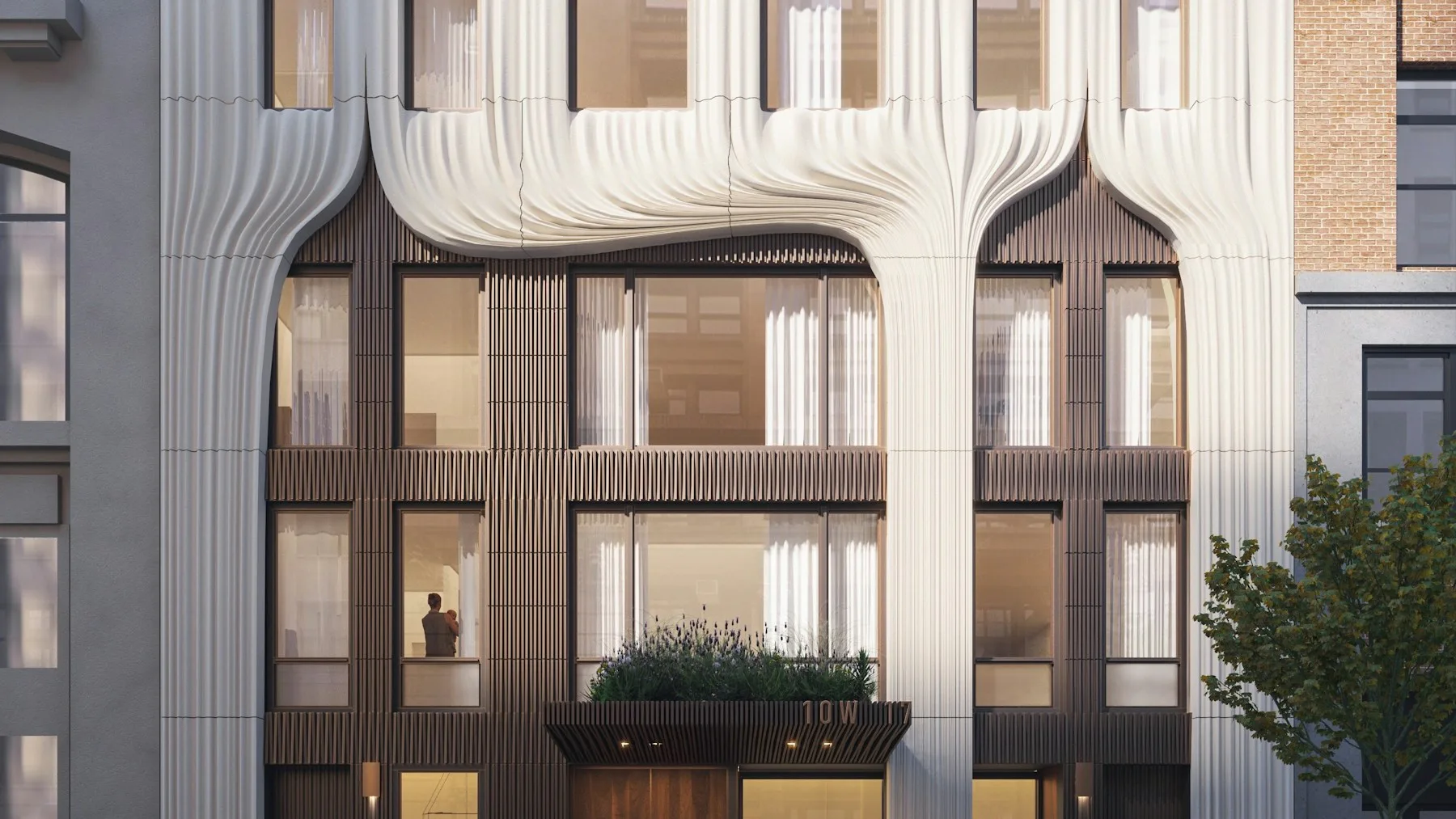 Modern facade with curved cream-colored upper panels, dark-framed glass doors and windows, and horizontal ribbed detailing by Ann Skinner.