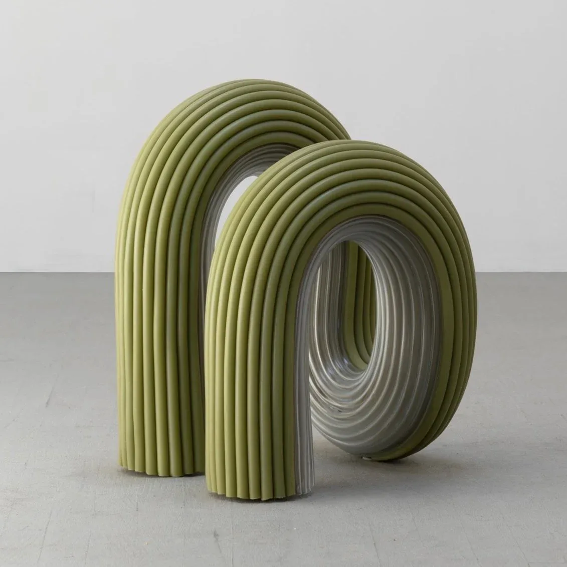 Two stacked organic cylindrical forms with ribbed yellow-green exterior surfaces and hollow interiors, photographed against a neutral background by Ara Thorose.
