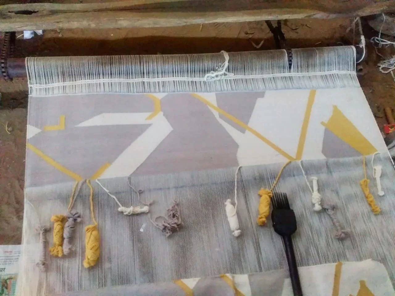 Textile design process showing yarn samples and woven patterns in yellow and neutral tones on a loom, by Arati Rao.