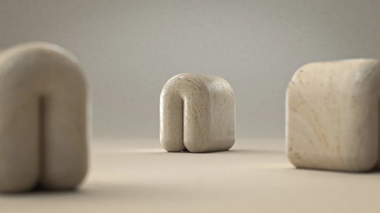 Three abstract marble sculptural forms with soft rounded edges in cream and white tones against a neutral background by Arthur Vallin.