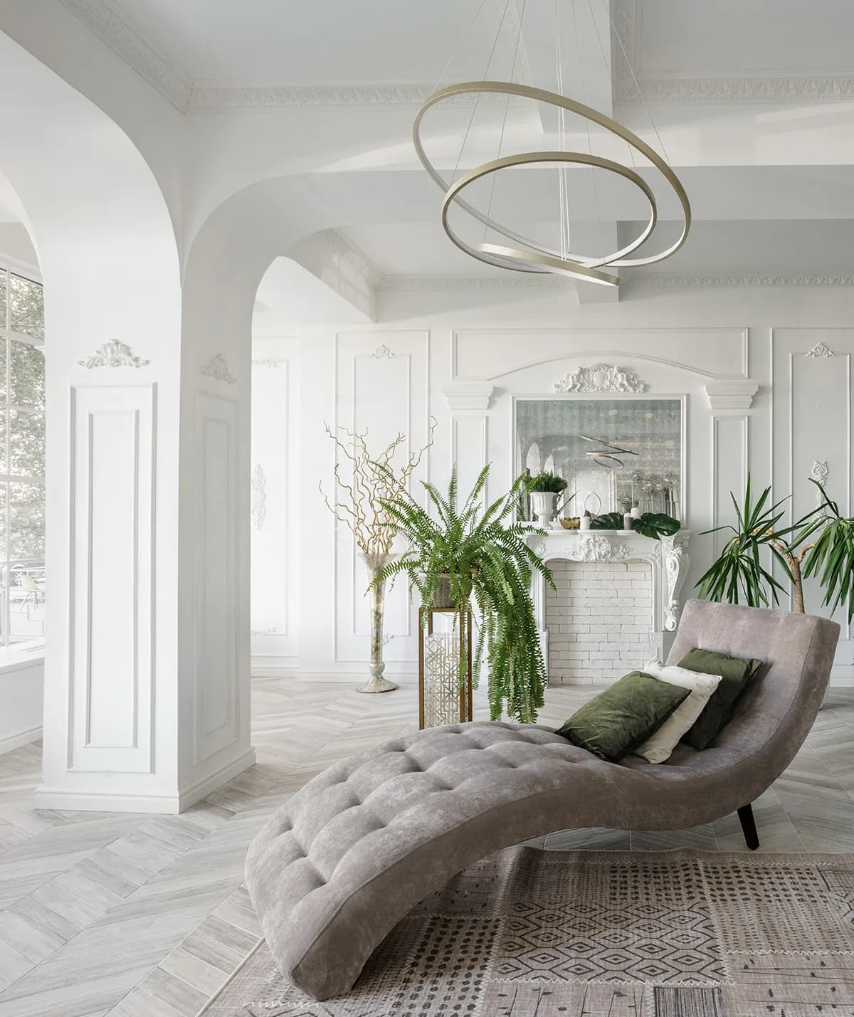 A minimalist white bathroom with curved archways, herringbone flooring, a sculptural chaise lounge, living plants, and modern pendant lighting by Bailee Klein.