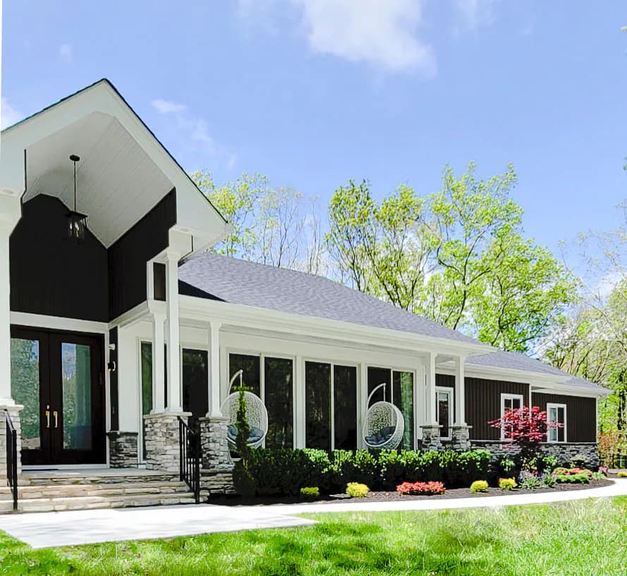 Modern farmhouse exterior with black and white color blocking, large black barn-style entry, expansive windows, and manicured landscaping by Bailee Klein.