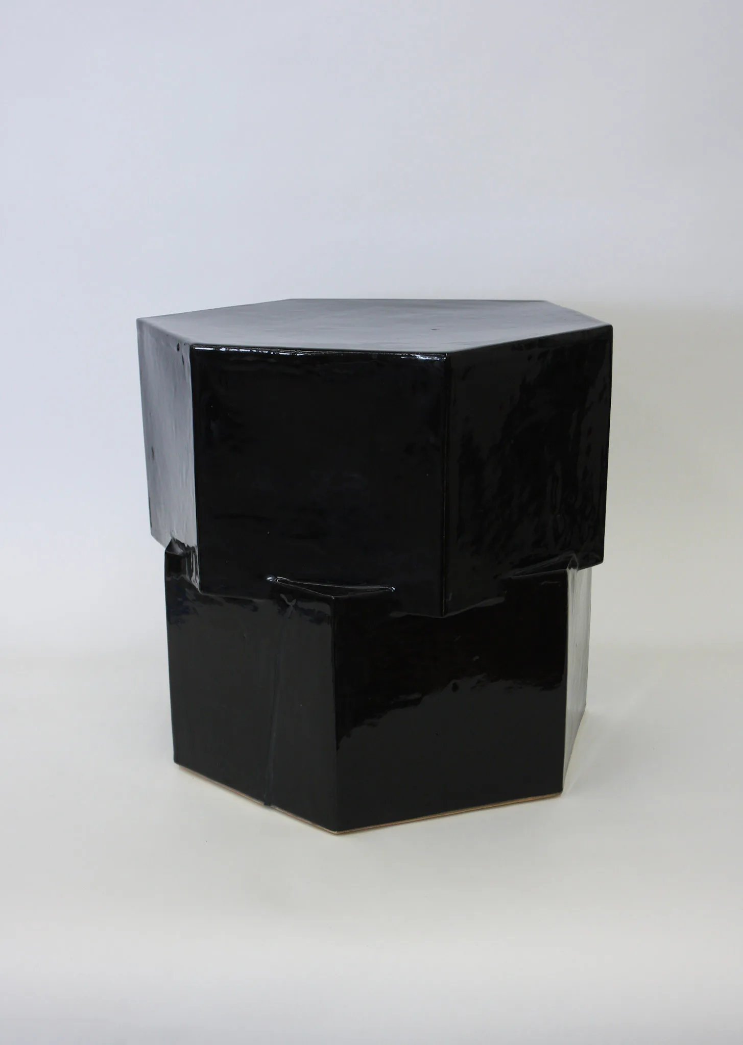 Black and gray geometric side table with hexagonal top and angular base, featuring glossy lacquered surfaces by Bari Ziperstein.