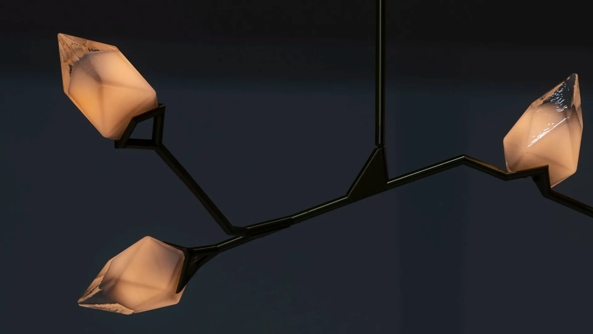 Three sculptural pendant lights with organic, folded forms suspended from black metal branches against a dark background, by Bec Brittain.