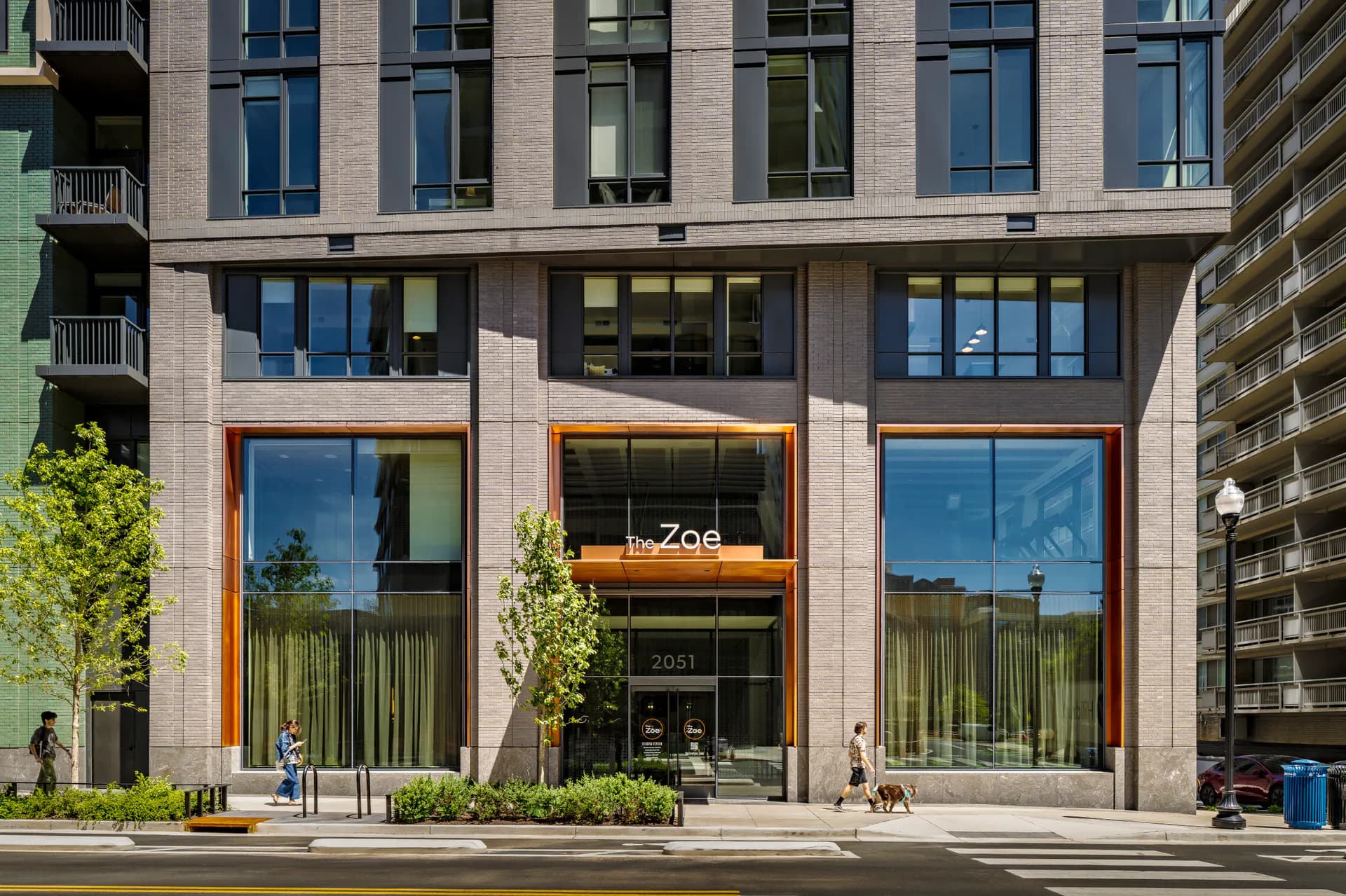 Ground-floor retail storefront with copper-framed windows, green vertical plantings, and modern materiality designed by Belen Cavdar.