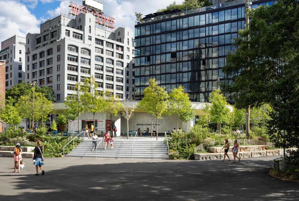 Contemporary plaza with paved ground, sculptural elements, and mature trees, flanked by modern residential buildings by Billie Tsien.