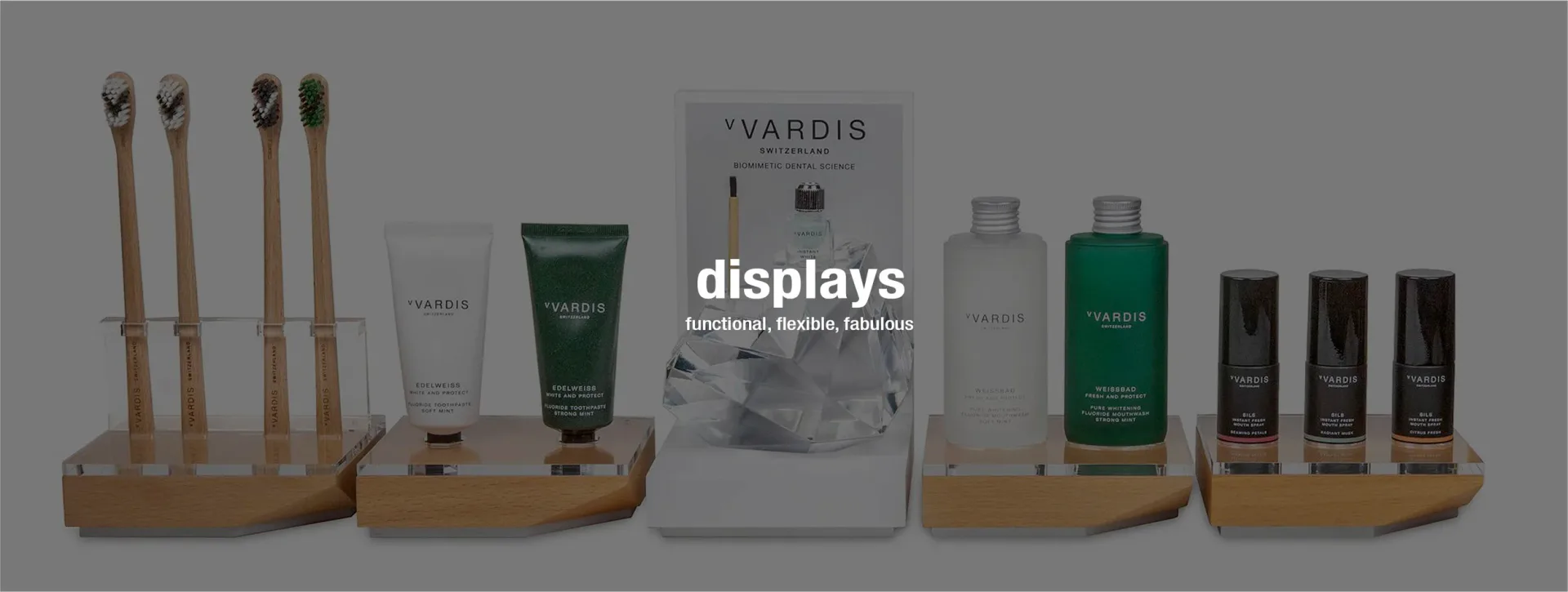 Product display setup for Yardis skincare line featuring wooden stands with bottles, tubes, and branded packaging showcasing the complete collection by Bruce Teitelbaum.
