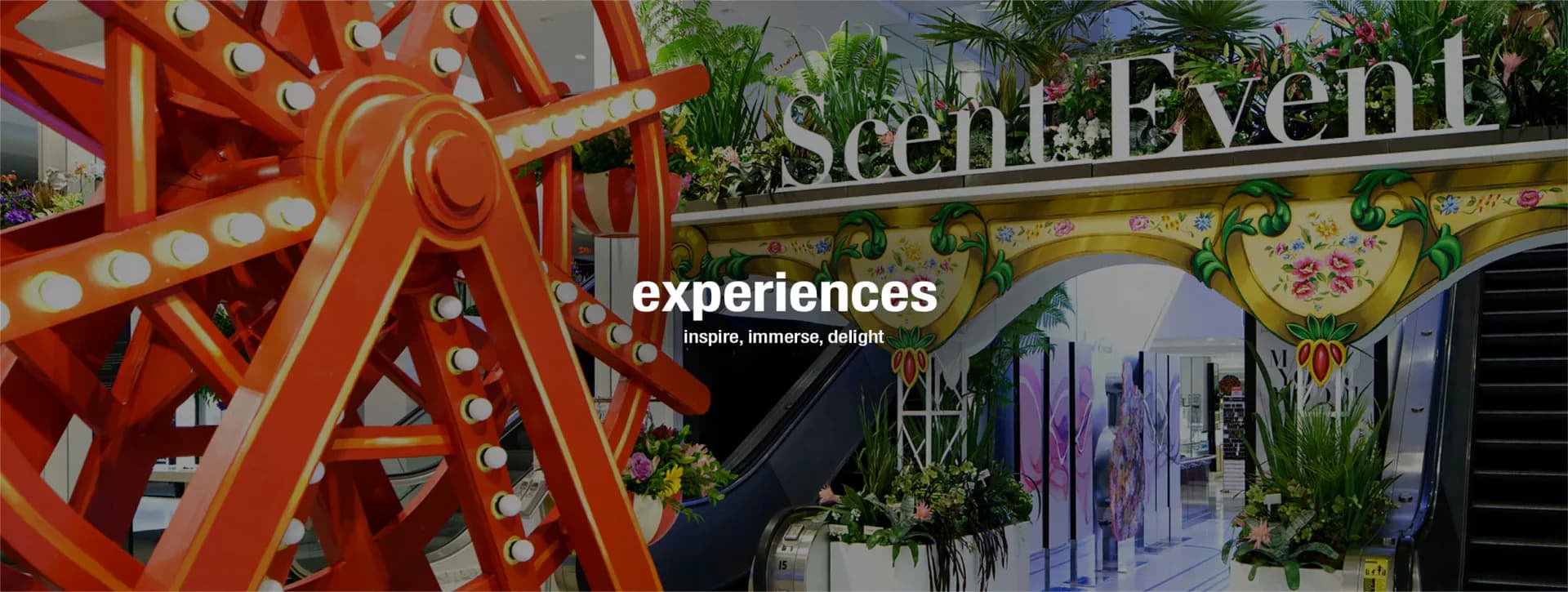 Vibrant event space featuring red illuminated sculptural elements, colorful signage, and botanical installations designed by Bruce Teitelbaum.