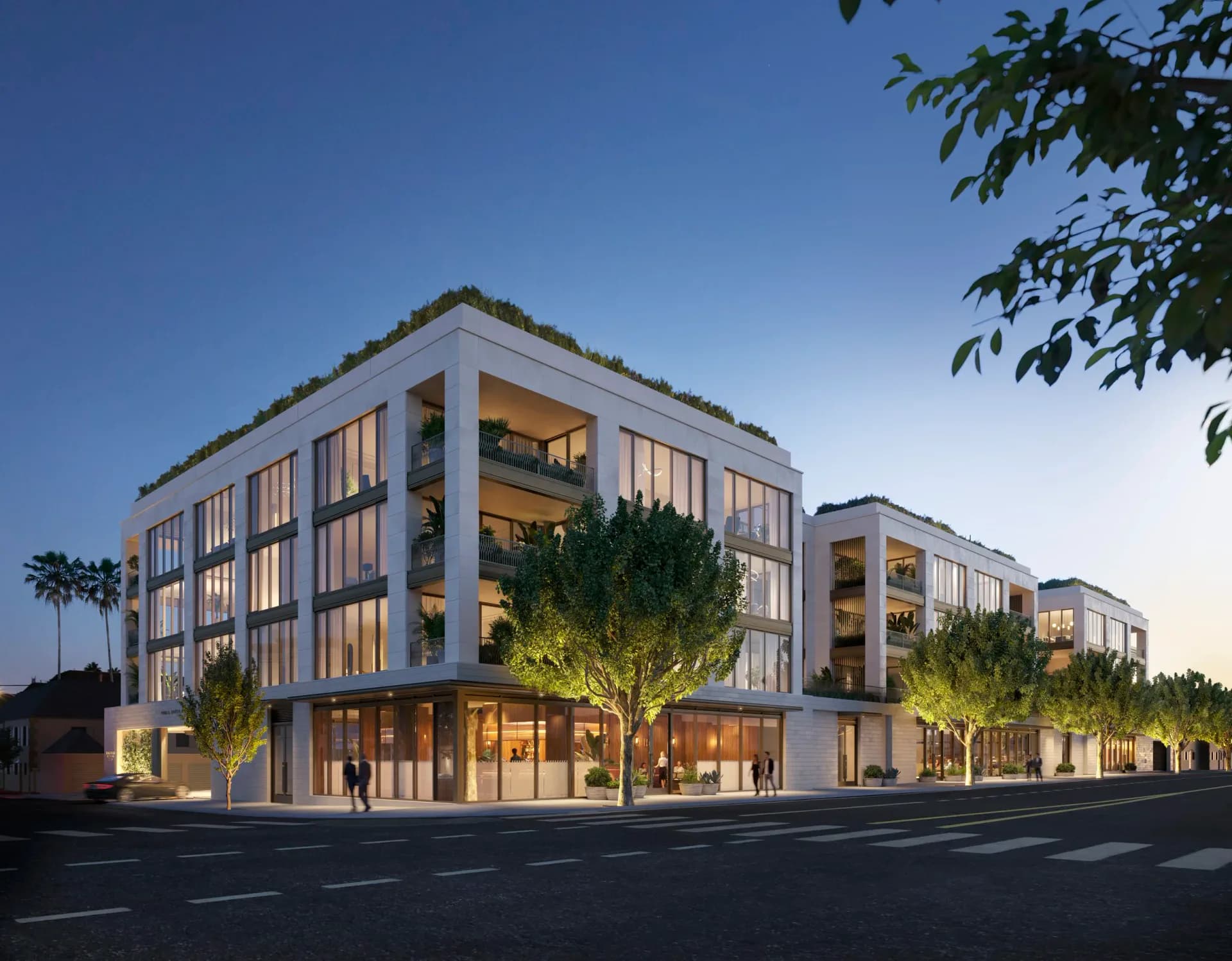 Modern residential building with illuminated facades at dusk, featuring repetitive window patterns, ground-floor retail, and landscaped courtyard by Cate Osborne.