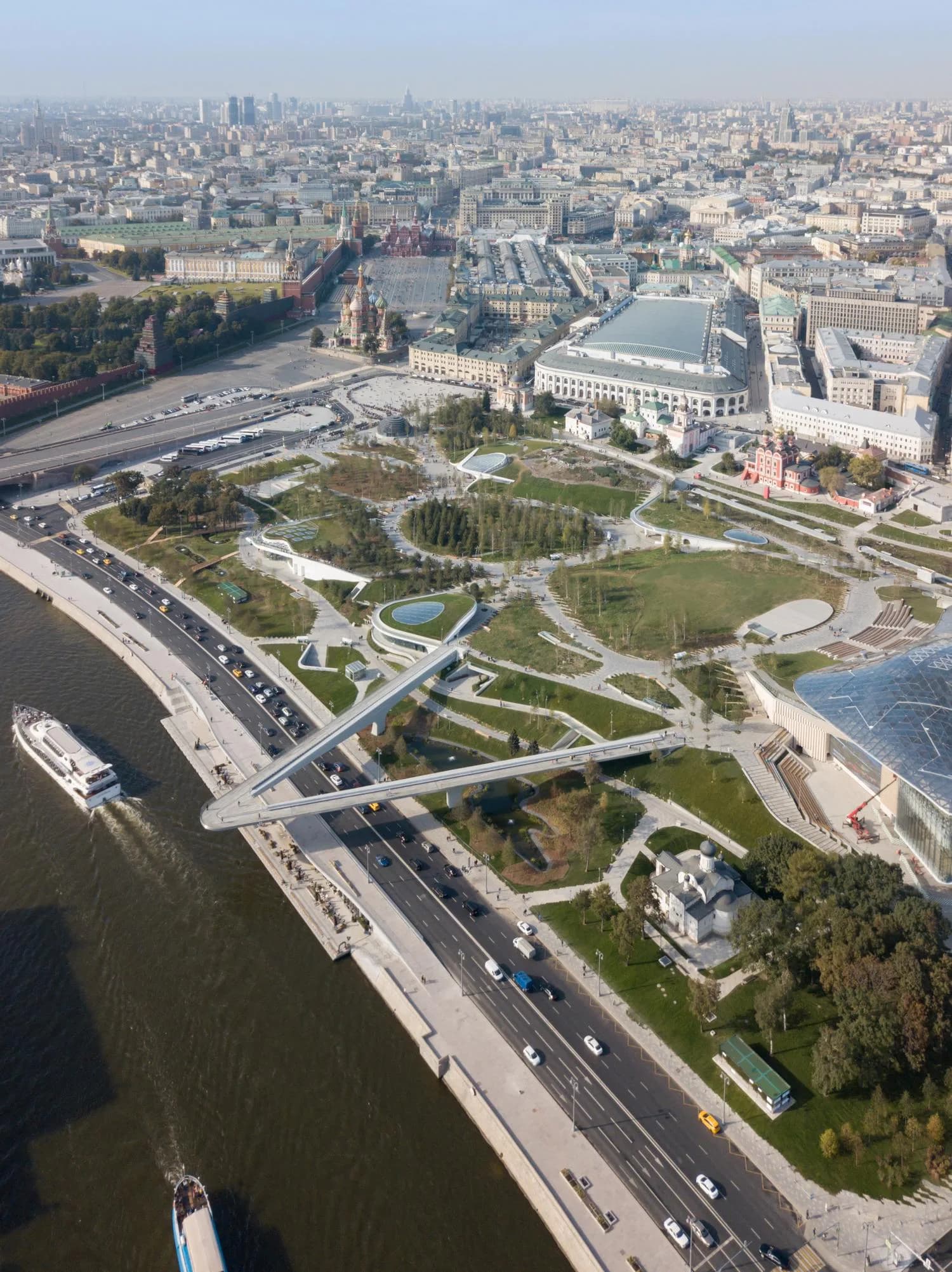 Aerial view of Zaryadye Park's landscaped grounds with serpentine pathways, green spaces, and modern structures along the Moscow River, designed by Charles Renfro.