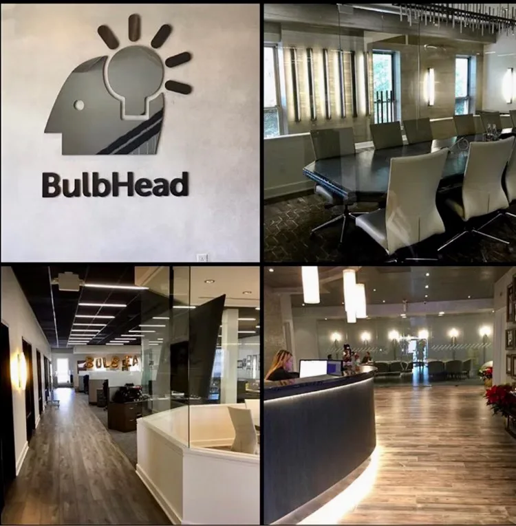 BulbHead office interior featuring modern conference room, reception desk with black and white finishes, wooden flooring, and bright lighting by Christina Marraccini.