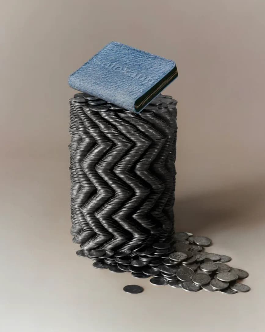 Sculptural installation featuring a textured cylindrical form with zigzag pattern topped by a blue square, with metallic discs spilling from the base by Ciara Dockery.