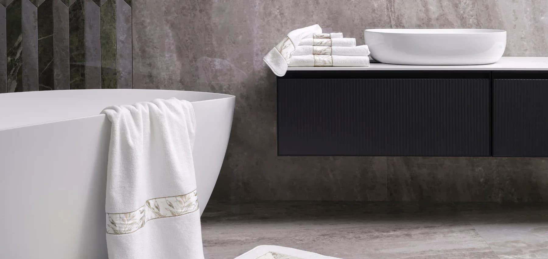 Contemporary bathroom with freestanding white tub, black vanity with vessel sink, concrete walls, and white towels by Claudia Godoy.