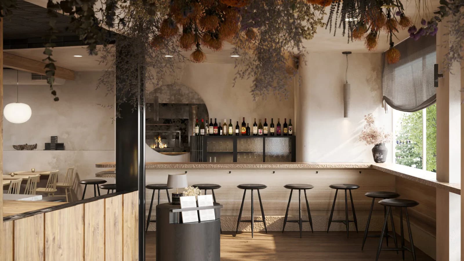 Modern wine bar interior with wooden cabinetry, suspended dried botanicals, bar seating, and natural light by Colleen Smith.
