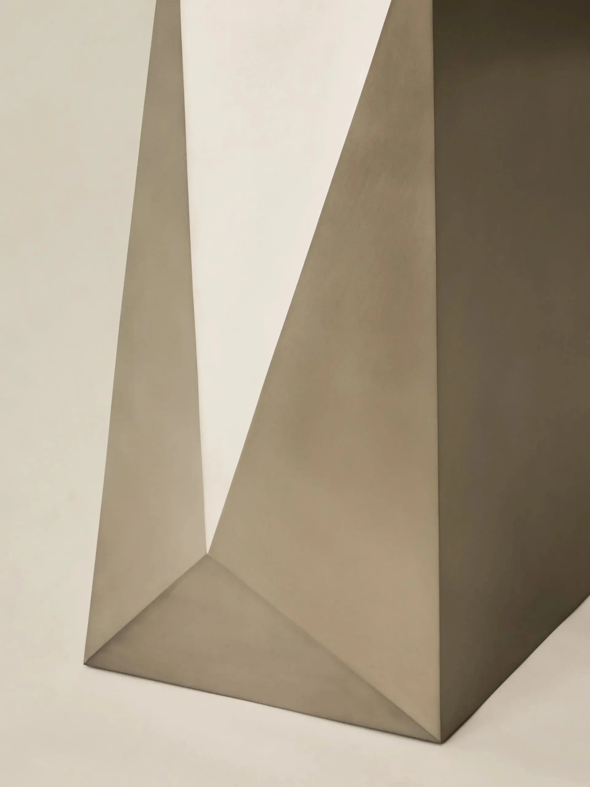 Geometric abstract sculpture with angular planes in warm taupe and brown tones, demonstrating form and shadow play by Crystal Ellis.