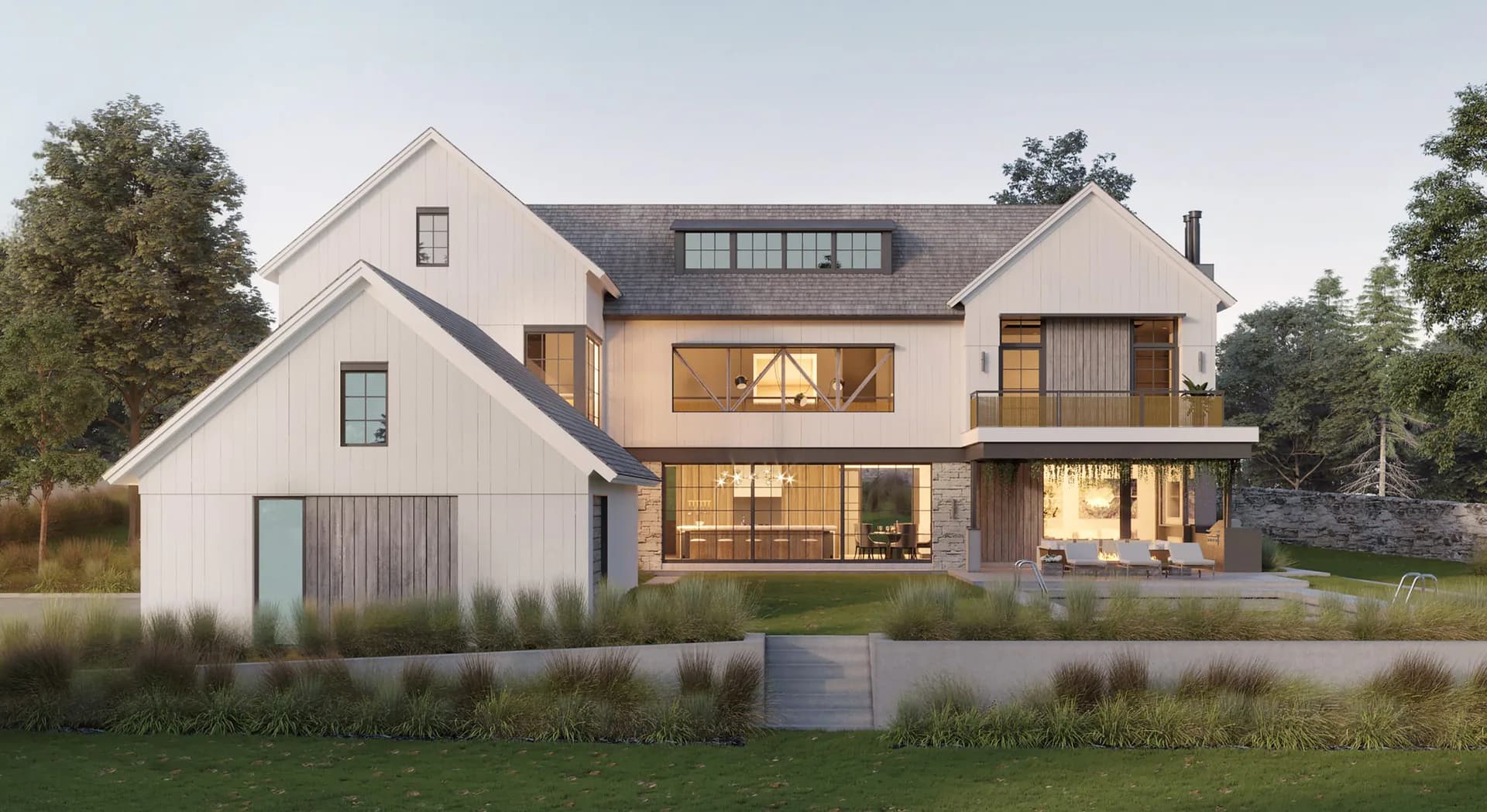 Modern farmhouse exterior with white and stone facade, illuminated windows, manicured landscaping, and pond reflection by Cynthia Vengrow.