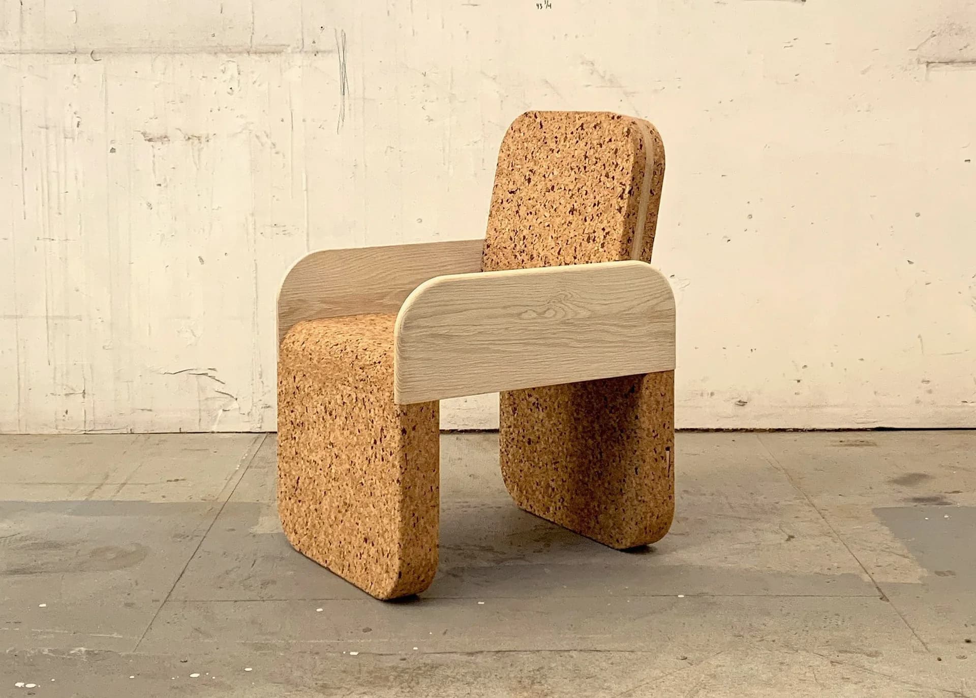 Cork and light wood chair with curved armrests and backrest in minimalist design by Daniel Michalik.