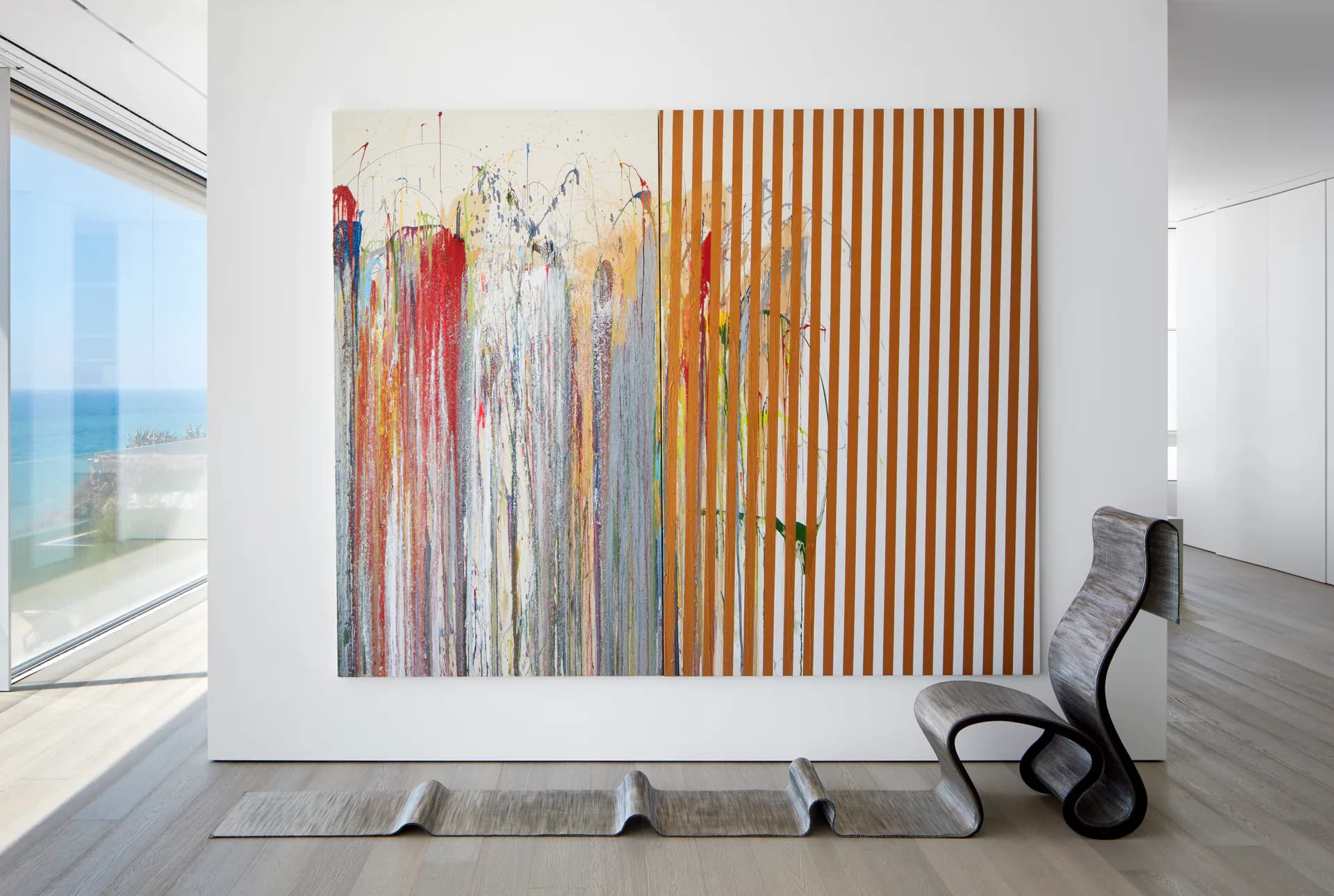 Modern minimalist interior with two abstract artworks on white wall, wooden striped panel, gray concrete floor, and sculptural black chair by Daria Karelina.