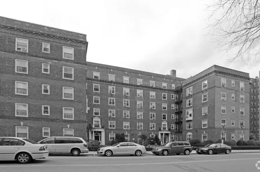 Mid-century brick residential buildings with uniform fenestration and parked cars on street, architectural documentation by David Jhee.
