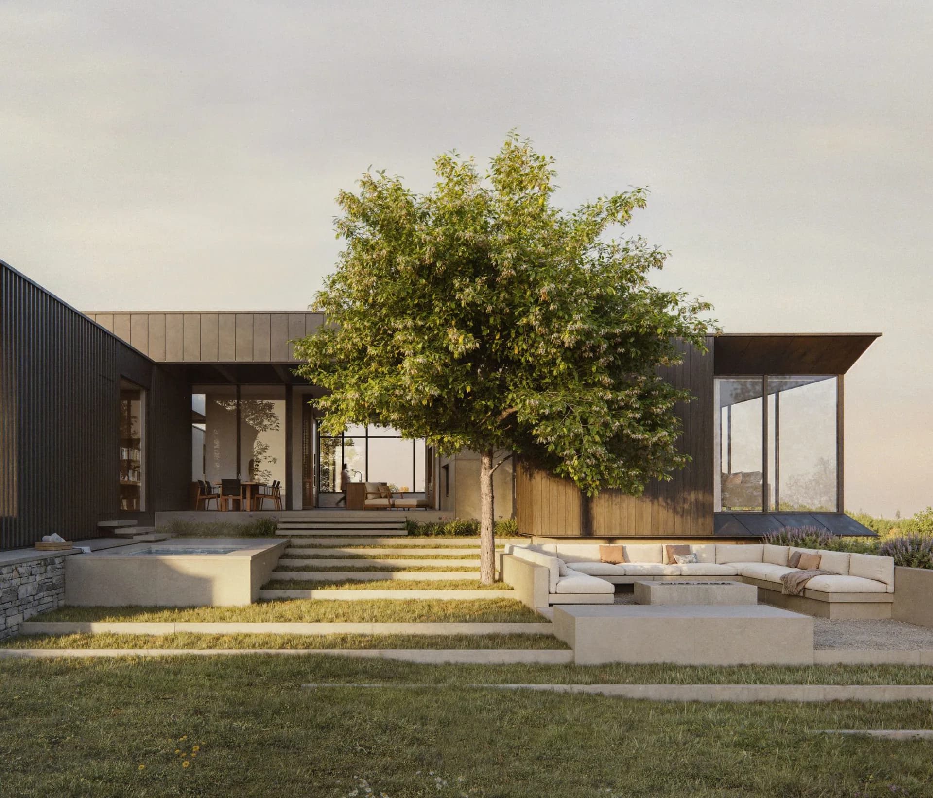 Modern residential exterior with dark metal cladding, large glazed openings, concrete terracing, and a mature tree in the courtyard by Deborah Berke.