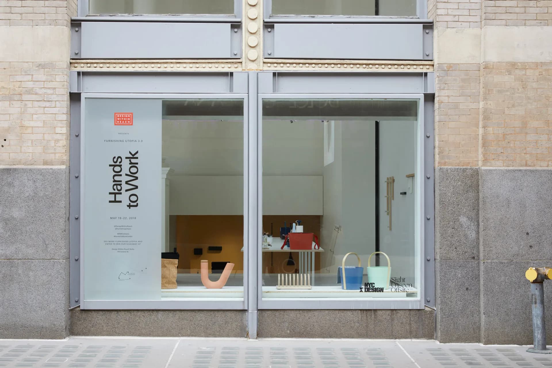 Storefront for Hands to Work bookstore featuring minimalist design with large windows, white framing, and carefully curated interior display by Dylan Davis.