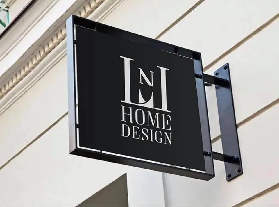 Black signage with white 'LNI HOME DESIGN' text mounted on a light-colored building facade, showcasing branding installation work by Elena Nesterova.