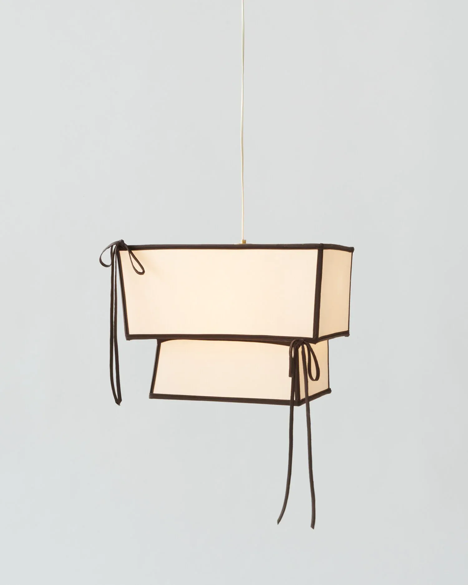 Line drawing of a cream-colored fabric pendant light fixture with brown outlines and hanging cord details, by Eny Lee Parker.
