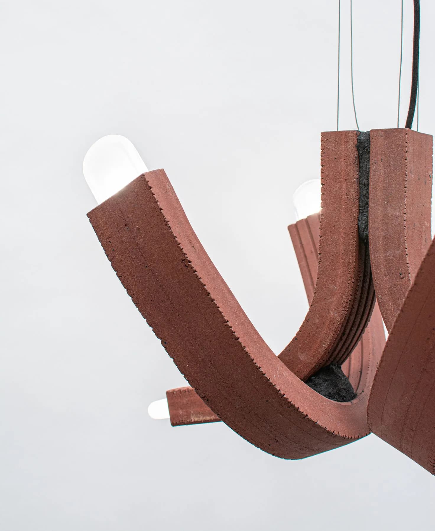 Suspended brown fabric installation with curved organic forms and exposed zipper details against white background by Floris Wubben.