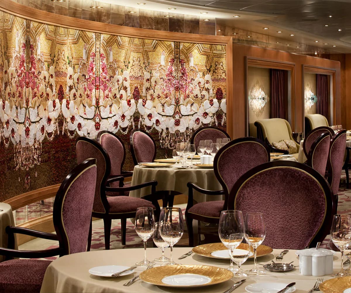 Elegant fine dining restaurant with burgundy velvet chairs, cream tablecloths, and ornate chandelier wall mural in warm gold tones by Francesca Bucci.
