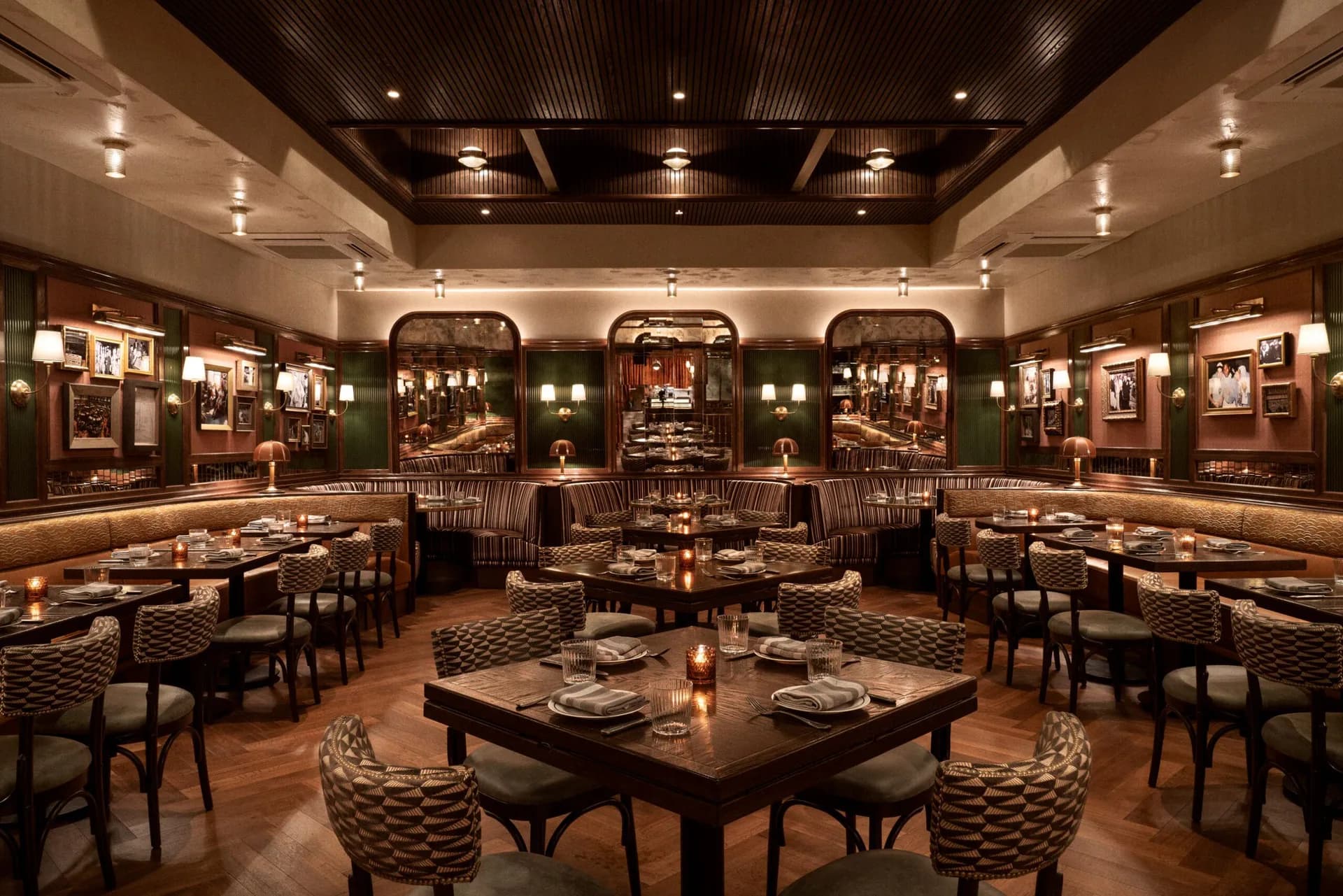 Elegant fine dining restaurant interior with dark wood tables, patterned upholstered chairs, warm ambient lighting, and gallery-style wall displays by Gary Wong.