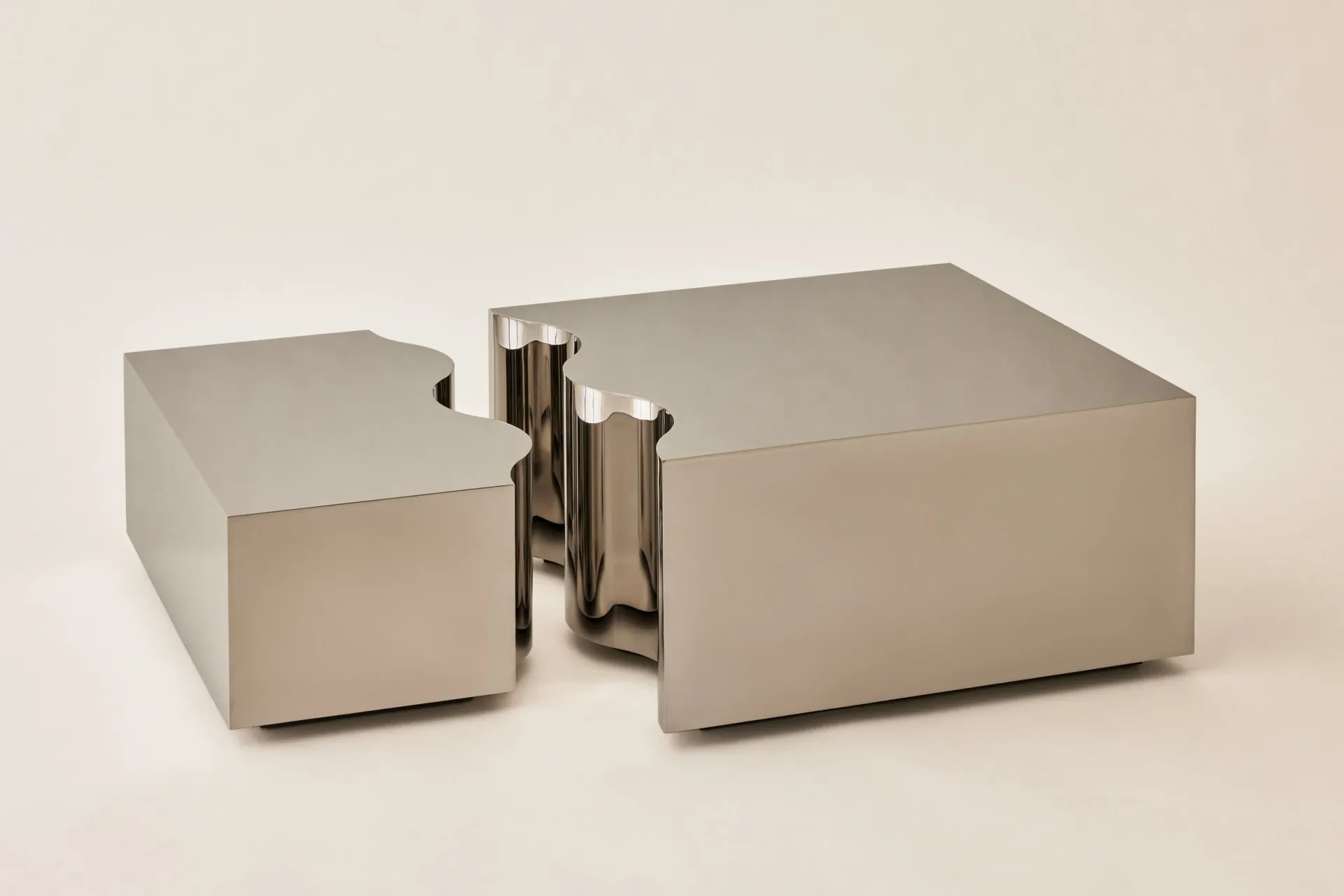Sculptural furniture installation featuring geometric concrete blocks and polished metal cylindrical forms in neutral tones by Hillary Petrie.
