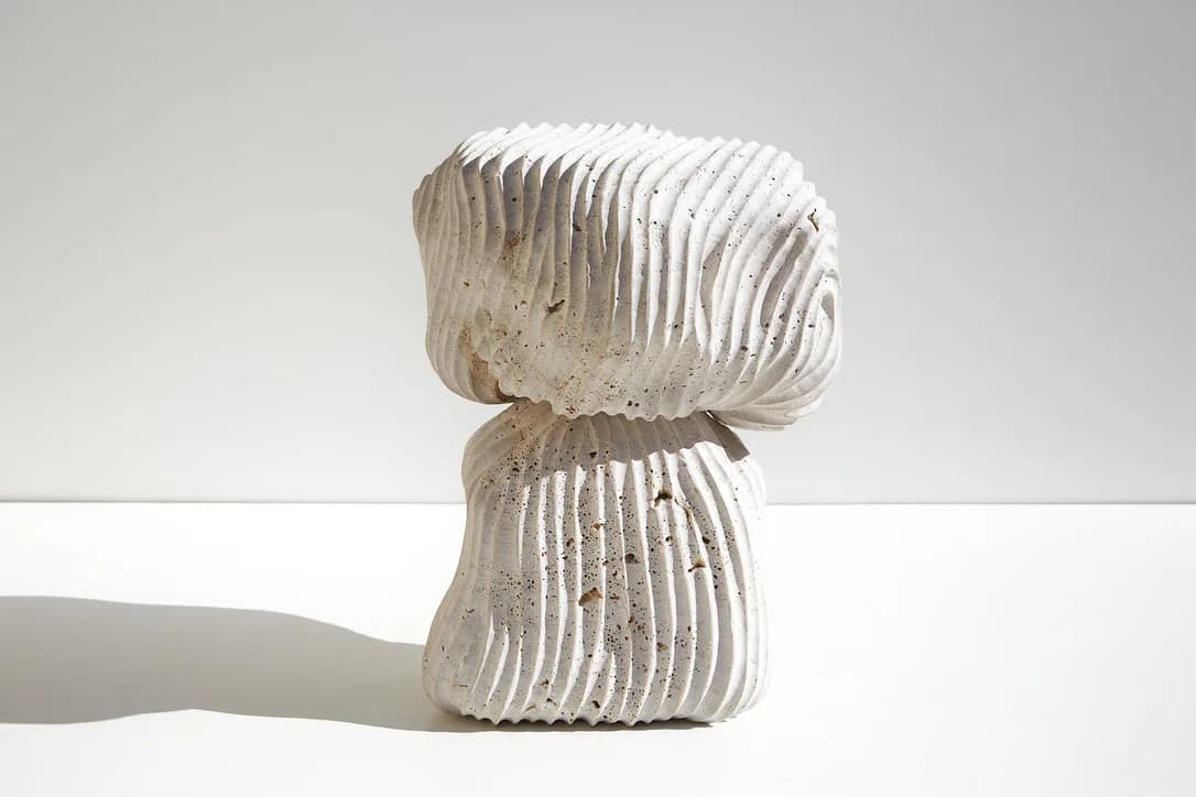 Sculptural white ribbed ceramic or plaster form with organic bulbous shapes stacked vertically, photographed against neutral background by Ian Collings.