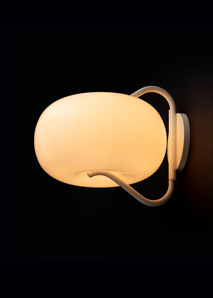Warm-toned pendant lighting fixture with a rounded opal glass shade and curved wooden arm details by Jamie Gray.