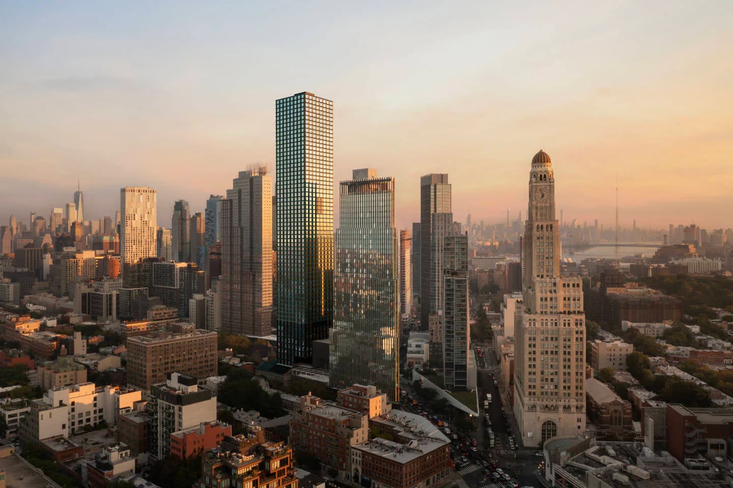 Golden-hour aerial photograph of Manhattan's downtown skyline featuring modernist towers and historic architecture bathed in warm sunset light by Jared Della Valle.