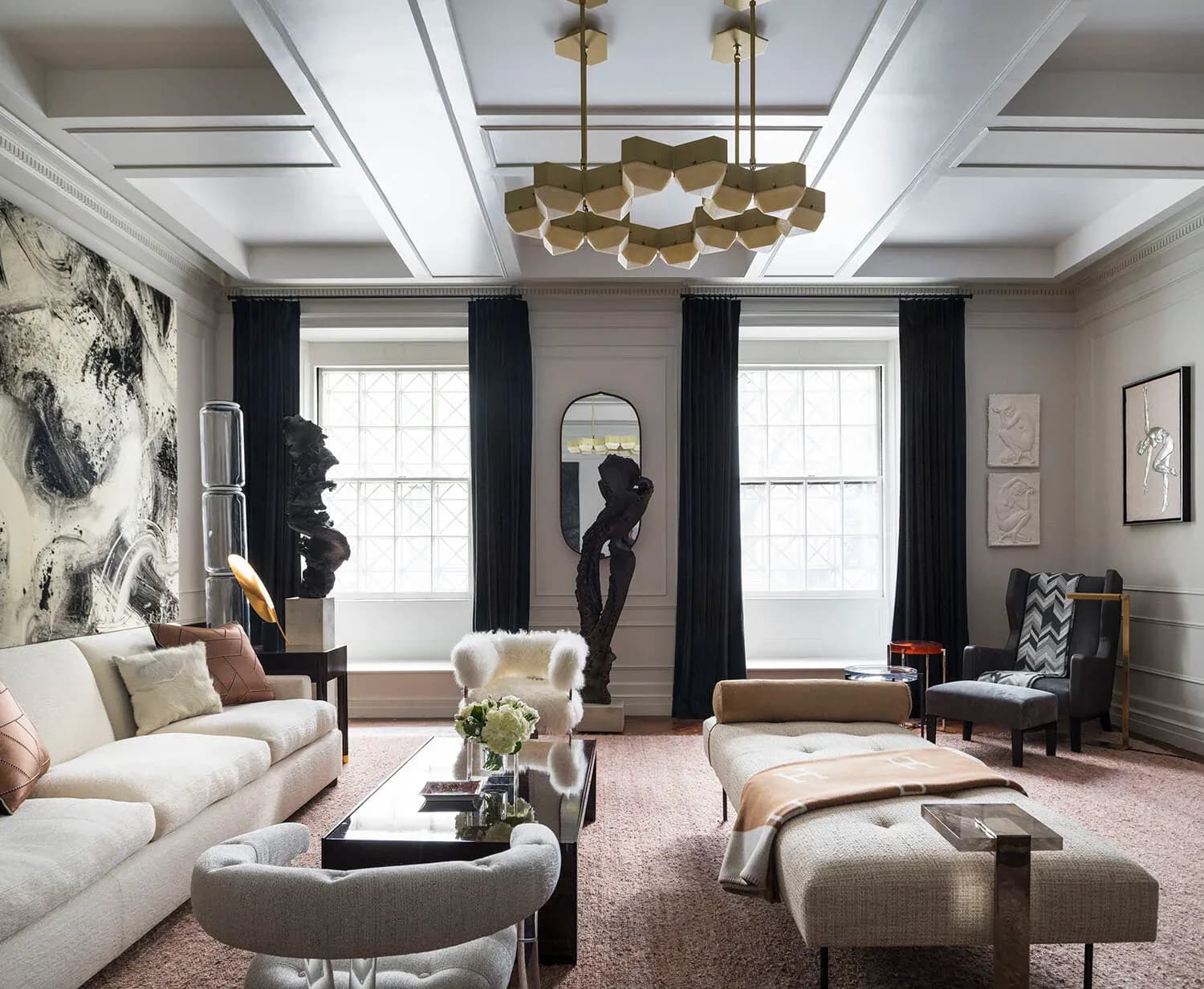 Elegant living room with cream sofa, brass pendant fixture, black curtains, mauve rug, and sculptural accessories in neutral palette by Jasmine Lam.