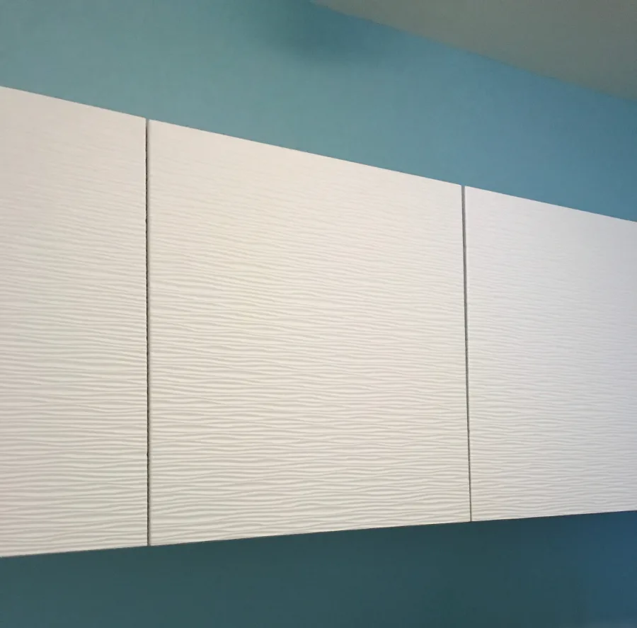 Modern interior wall with three white textured panels separated by subtle vertical reveals, teal ceiling above, minimal geometric aesthetic by Jean Herron.