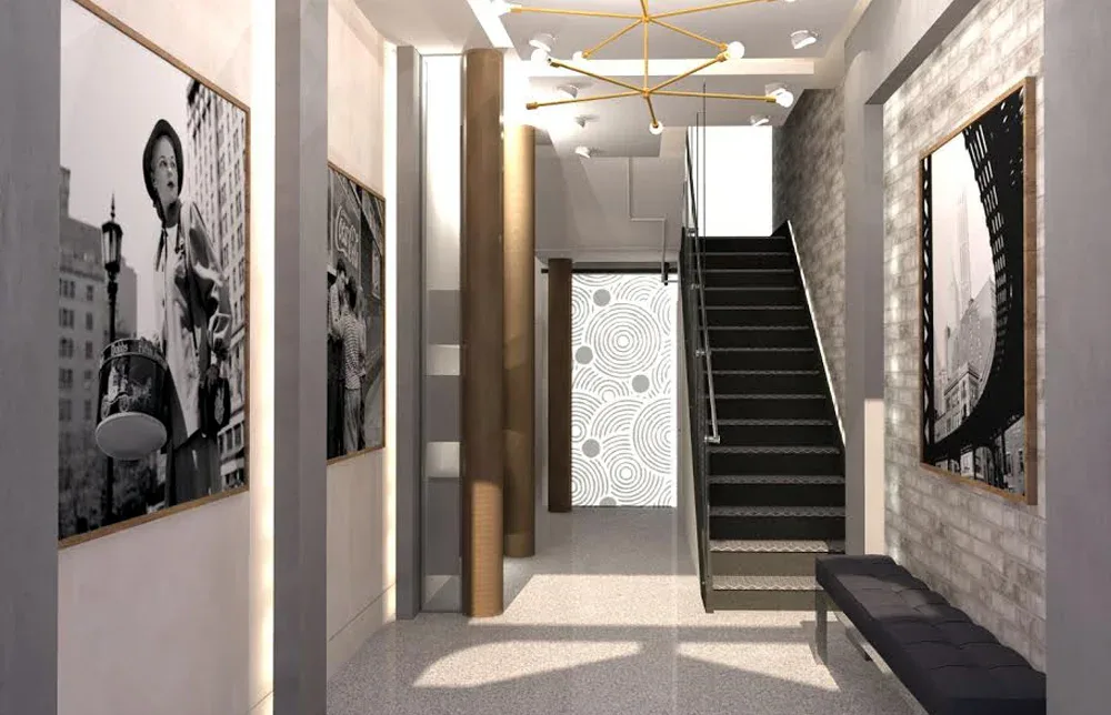 Modern stairwell with concrete and wood finishes, black-and-white gallery artwork on walls, and natural light from above, designed by Jeanne Isaacson.