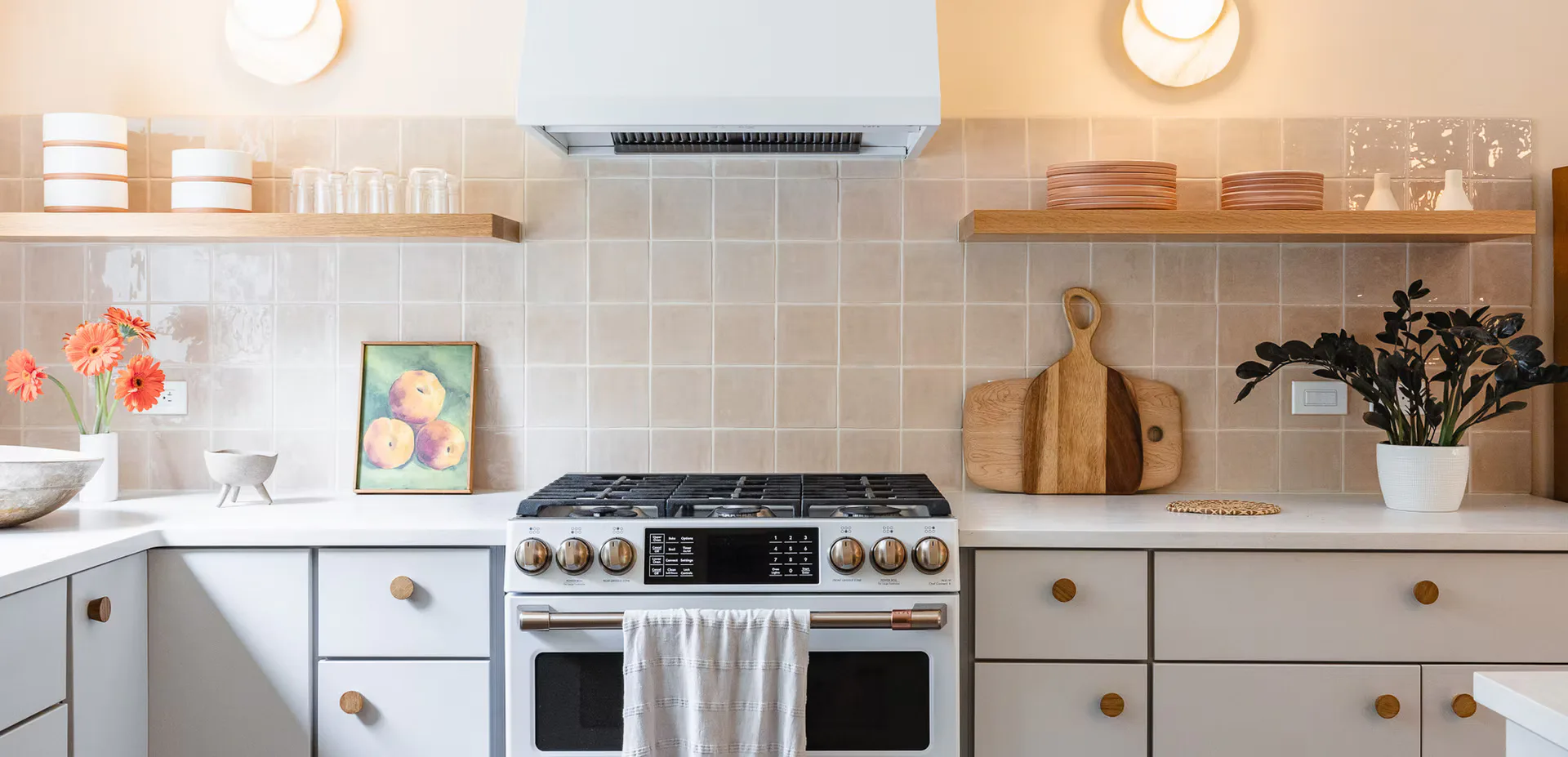 Bright modern kitchen with white cabinetry, brass hardware, dual ovens, gas cooktop, subway tile backsplash, and warm wood accents by Jennifer Salvemini.