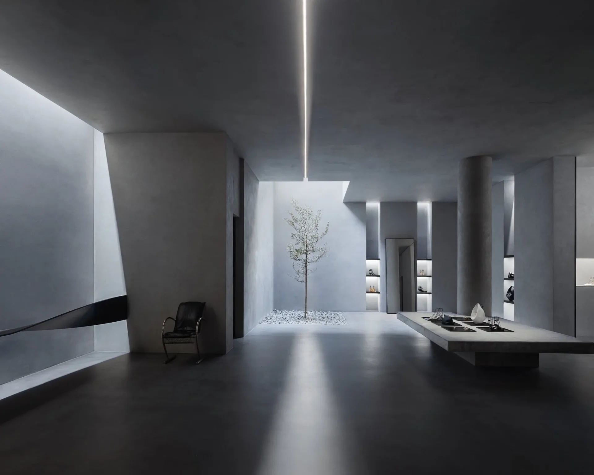 Minimalist white gallery space with curved gray walls, linear ceiling light, and a solitary tree by Jessica Hyland.