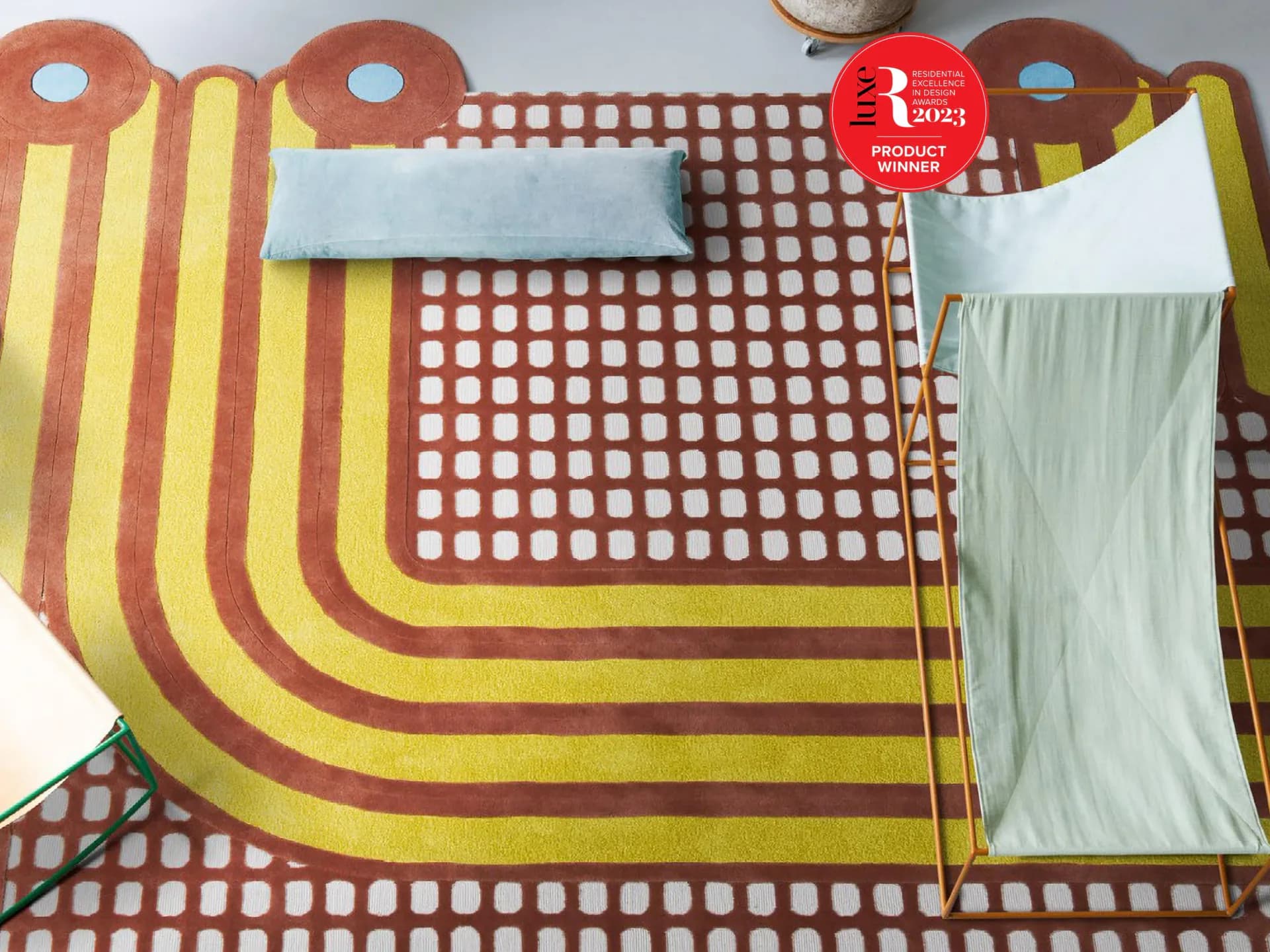 Colorful textile installation with red and yellow striped fabric and geometric patterned elements arranged on floor by Johanna Keller.