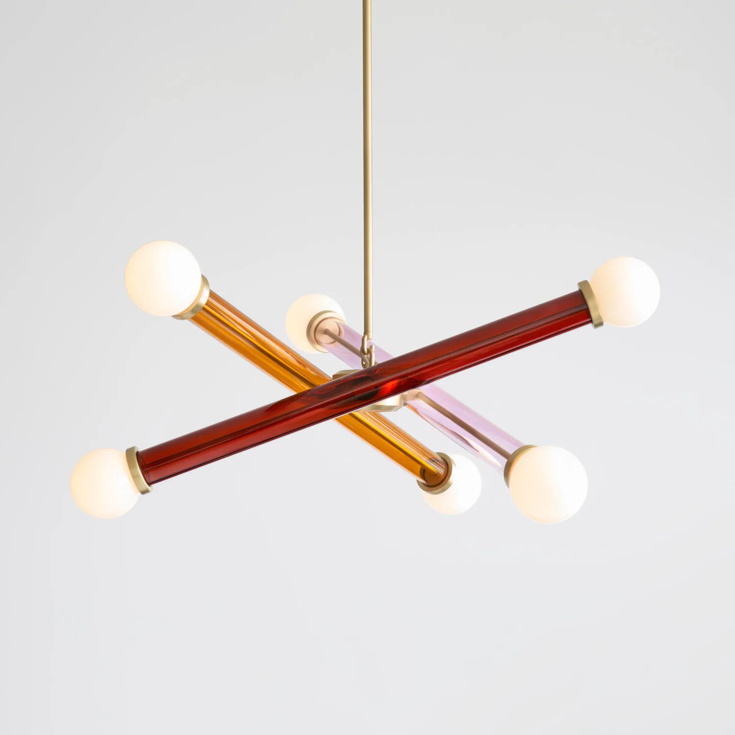 Modern pendant light fixture featuring crossed brass and red glass tubes with four frosted white glass spheres, suspended by brass rod by Josh Metersky.