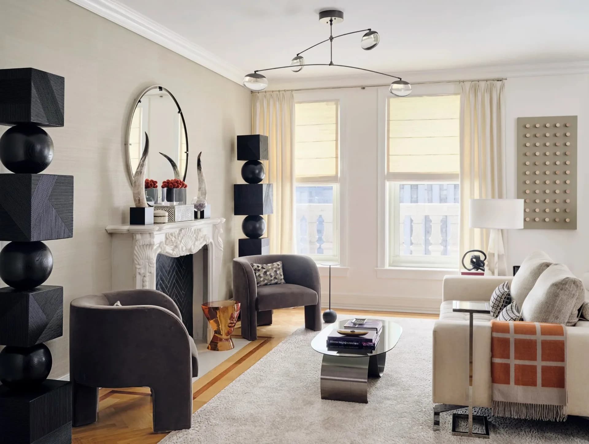 Contemporary living room with black sculptural accents, cream palette, modern pendant lighting, and curated furnishings by Josh Minter.
