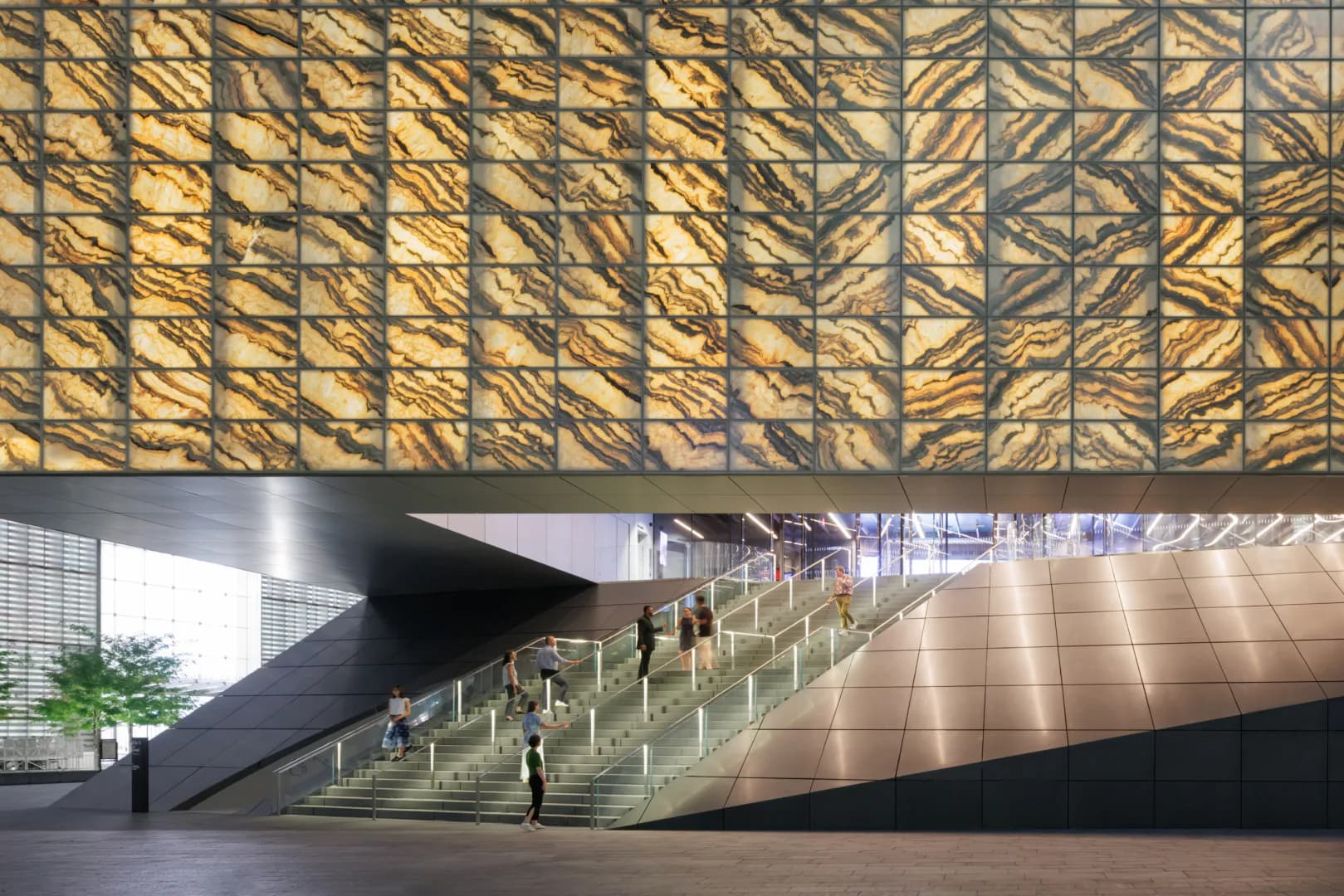 A modernist interior with a dramatic staircase, geometric patterned overhead canopy in gold tones, and expansive polished floor with figures for scale, by Joshua Ramus.